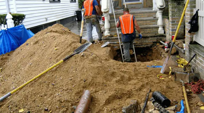 Contractors performing foundation protection and exterior drainage excavation near residential home steps in Tacoma, WA